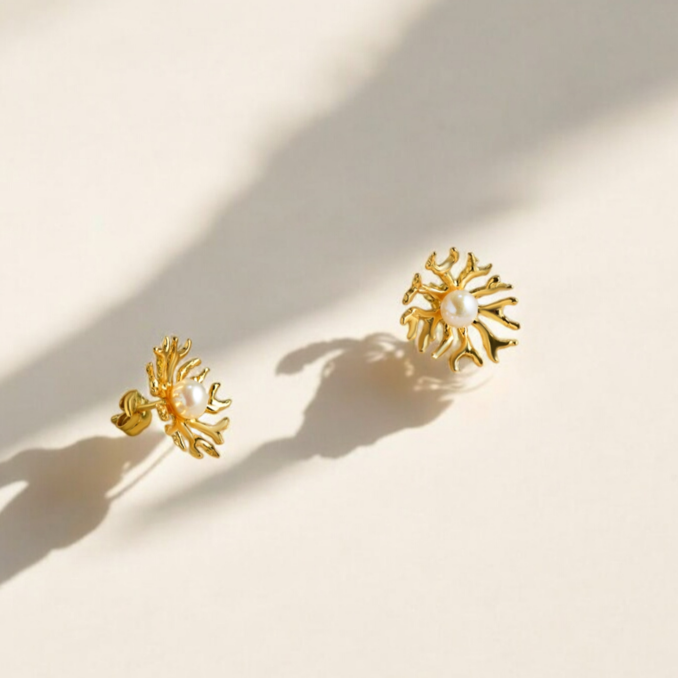 Gold earrings with a pearl in the middle.