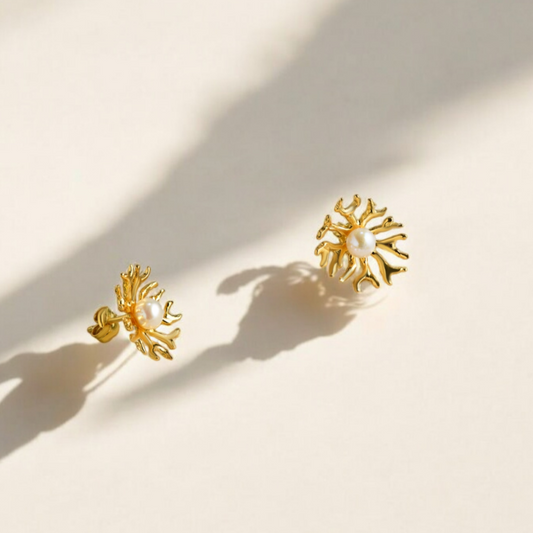 Gold earrings with a pearl in the middle. 